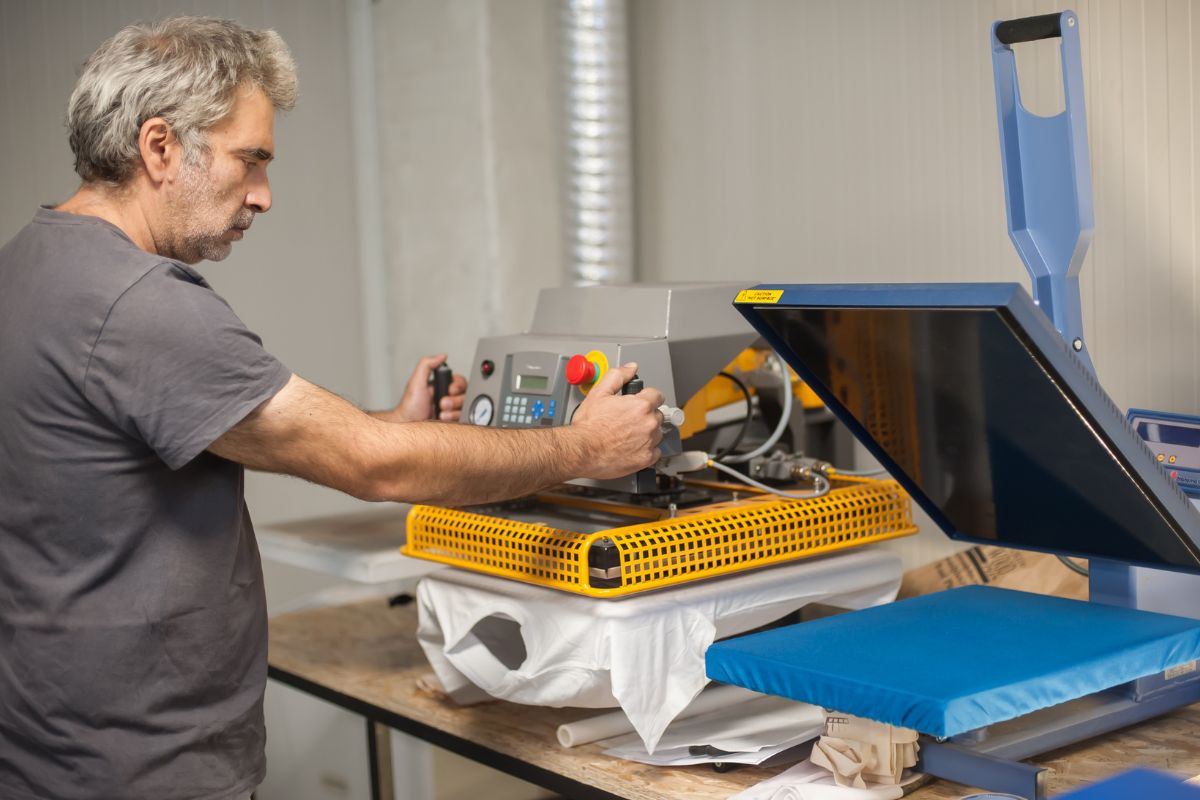 Un homme utilisant une machine d'impression numérique textile dans un atelier.